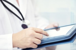 Hands of doctor indoors using tablet computer